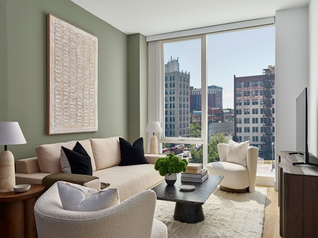 A living room with a large window overlooking a cityscape.
