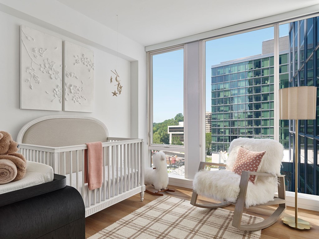 A baby's room with a white crib and a rocking chair.
