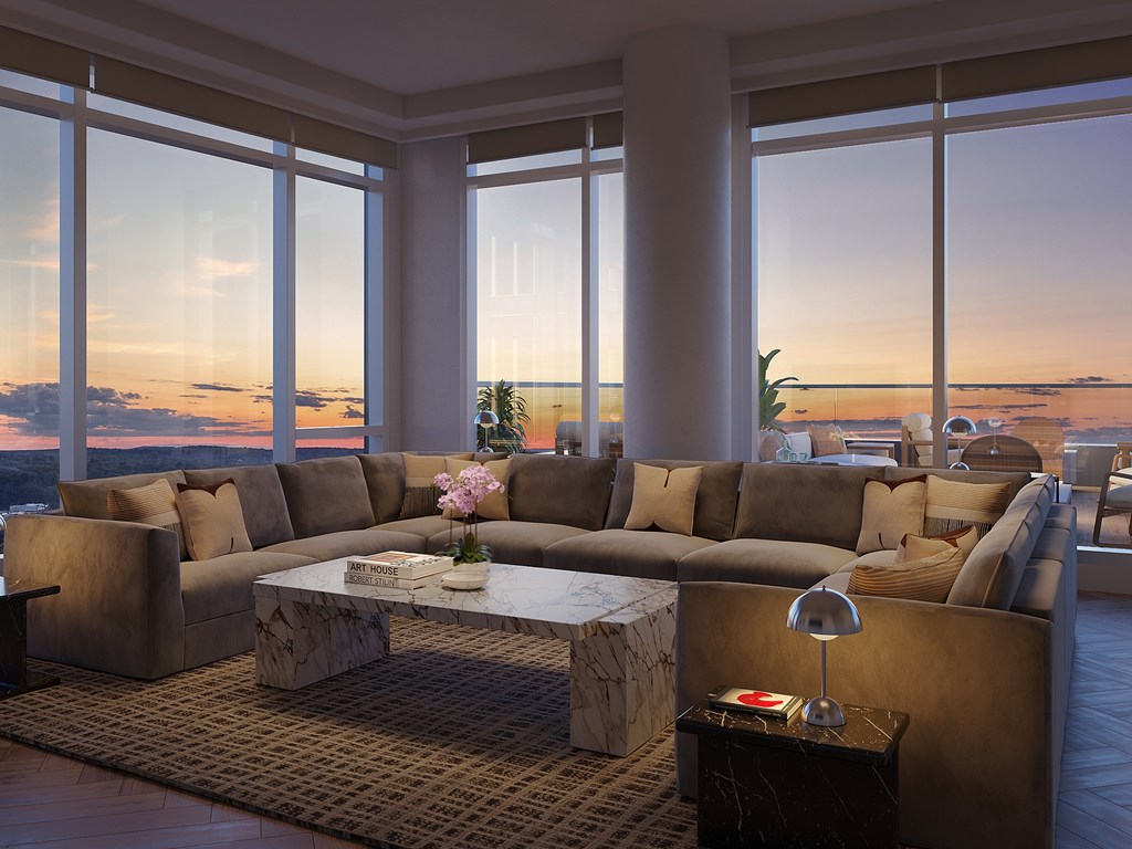 A living room with a large couch and a coffee table in front of a window.