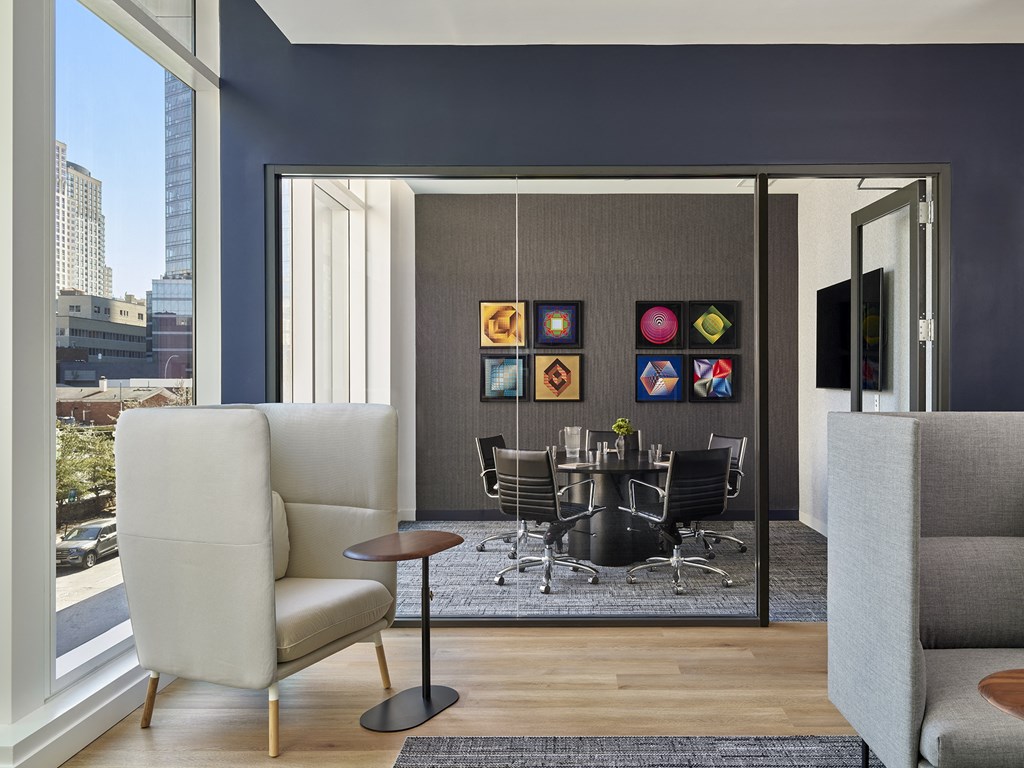 A modern living room with a grey sofa, a black table and a large window.