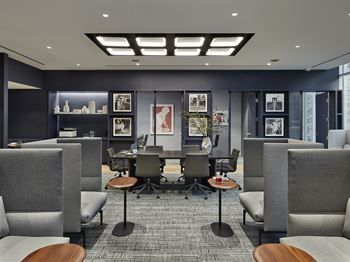 A modern office space with grey chairs and a carpeted floor.