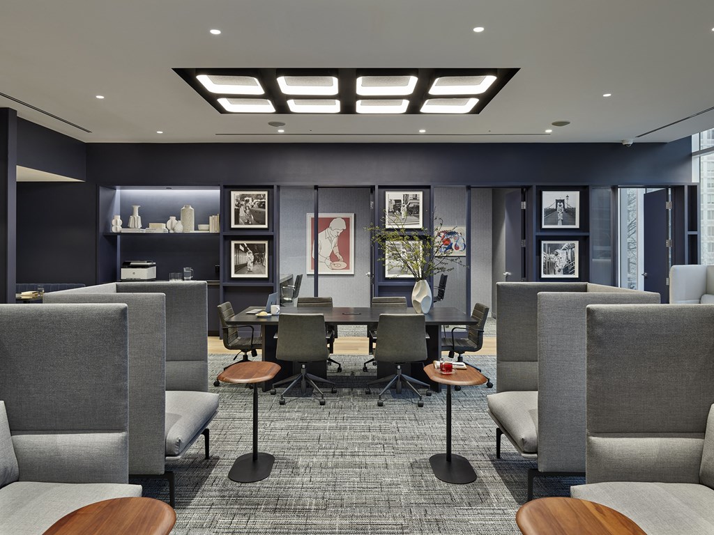 A modern office space with grey chairs and a carpeted floor.
