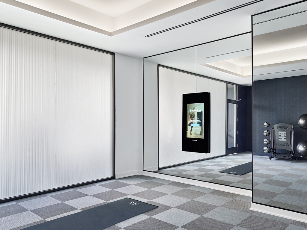 A bathroom with a tiled floor and a mirrored wall.