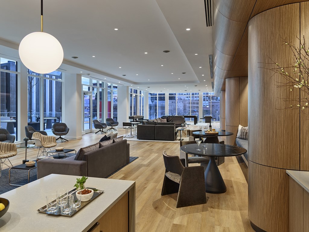 A modern living room with a large window and a dining table.