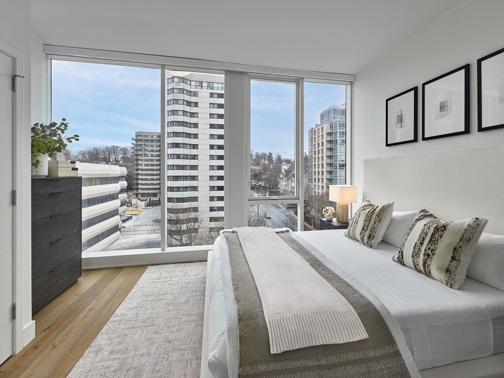 A bedroom with a large bed and a view of the city.