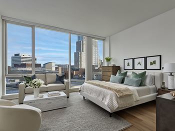 A bedroom with a large bed and a view of the city.