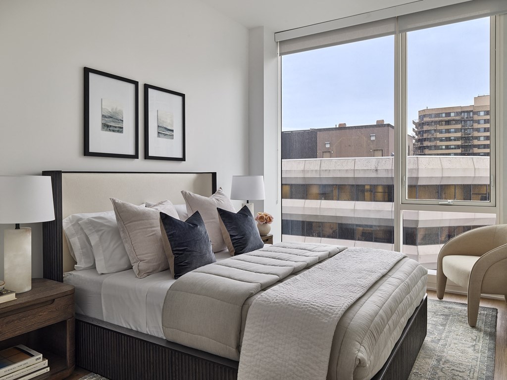 A bedroom with a large bed and a view of the city.