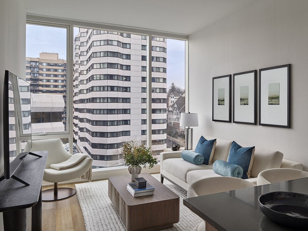 A modern living room with a large window overlooking a cityscape.