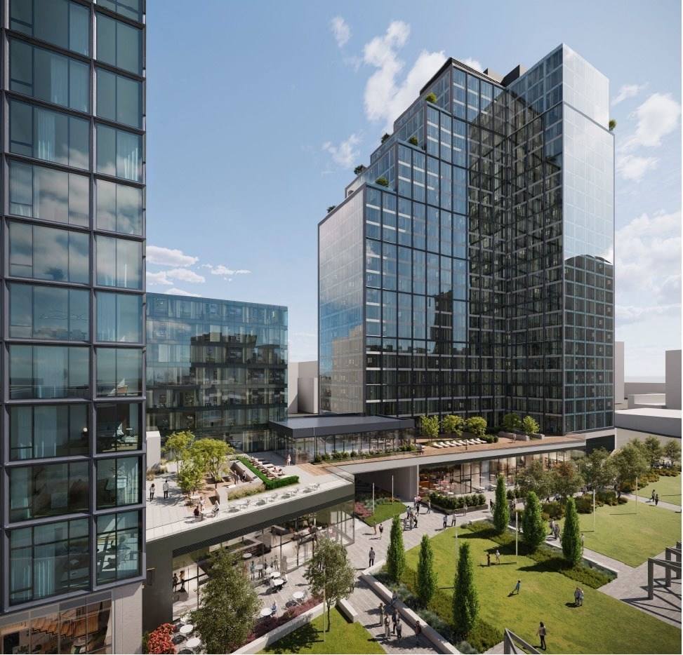 A modern glass building with a green lawn in front.
