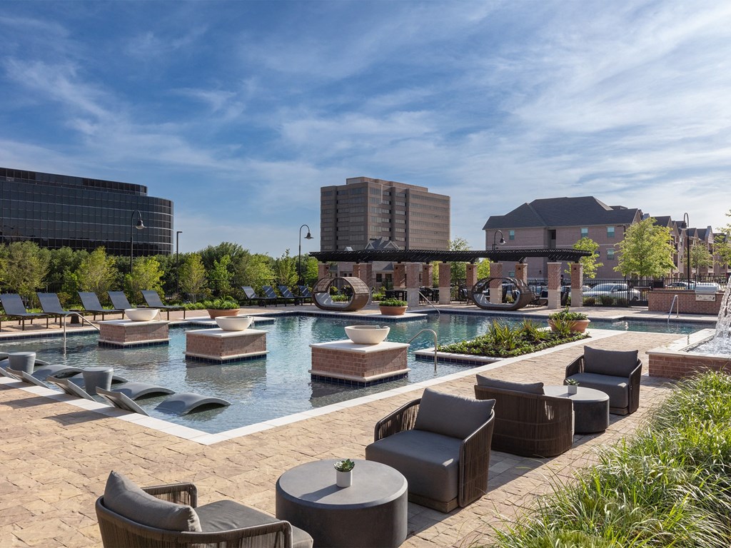 a resort style pool with lounge chairs and tables