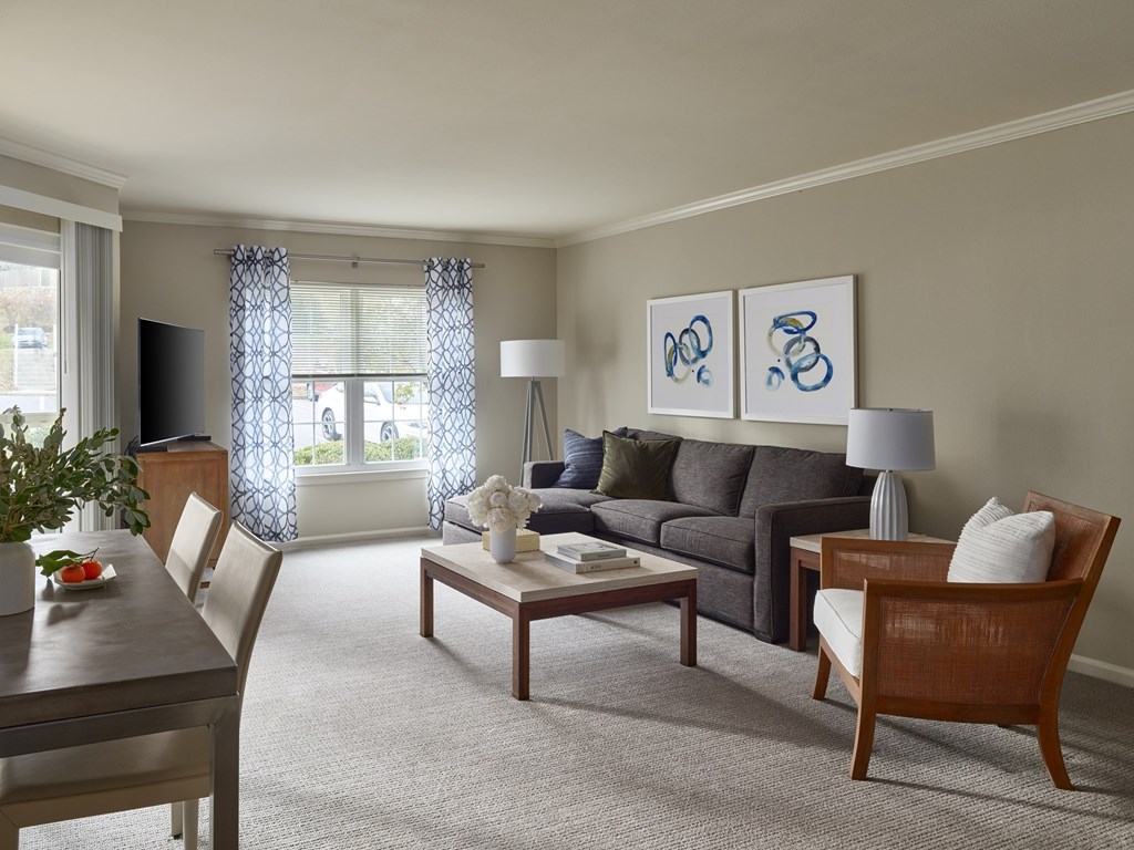 A living room with a grey couch, a wooden table and a television.