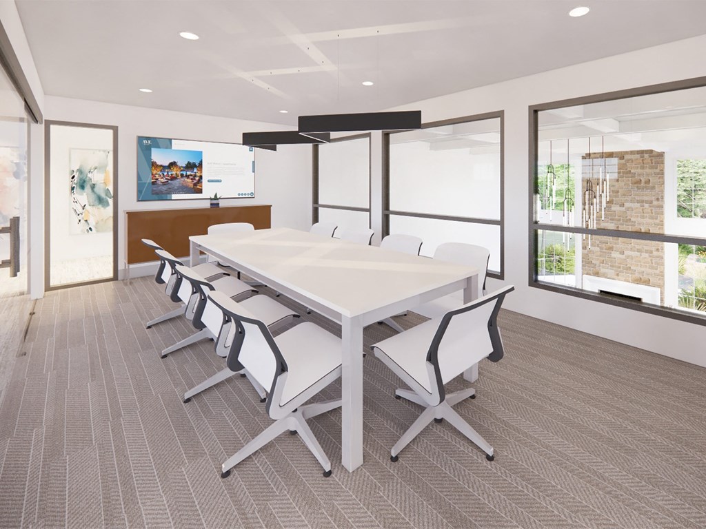 a conference room with a white table and chairs