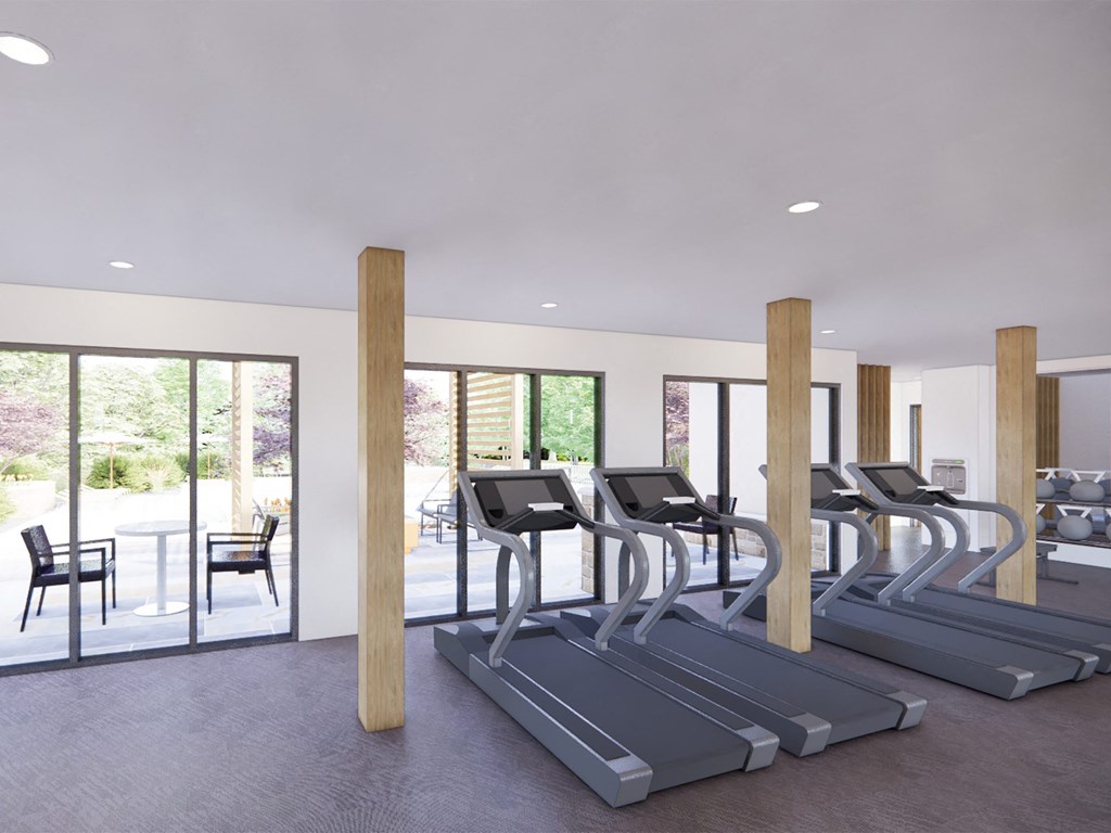 a row of treadmills in a gym with glass doors
