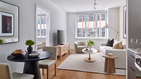 A modern living room with a dining table and chairs.