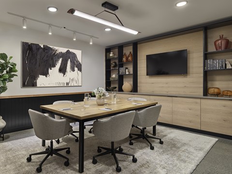 A conference room with a large table and chairs.
