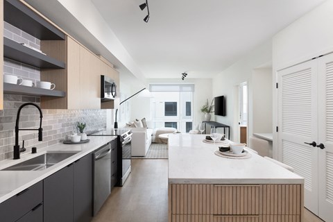 A modern kitchen with a white countertop and a sink with a black faucet.