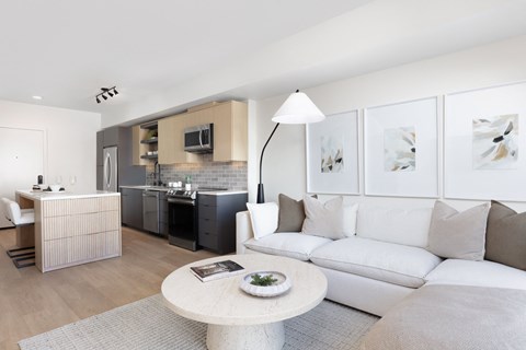 A modern living room with a white sofa and a grey rug.