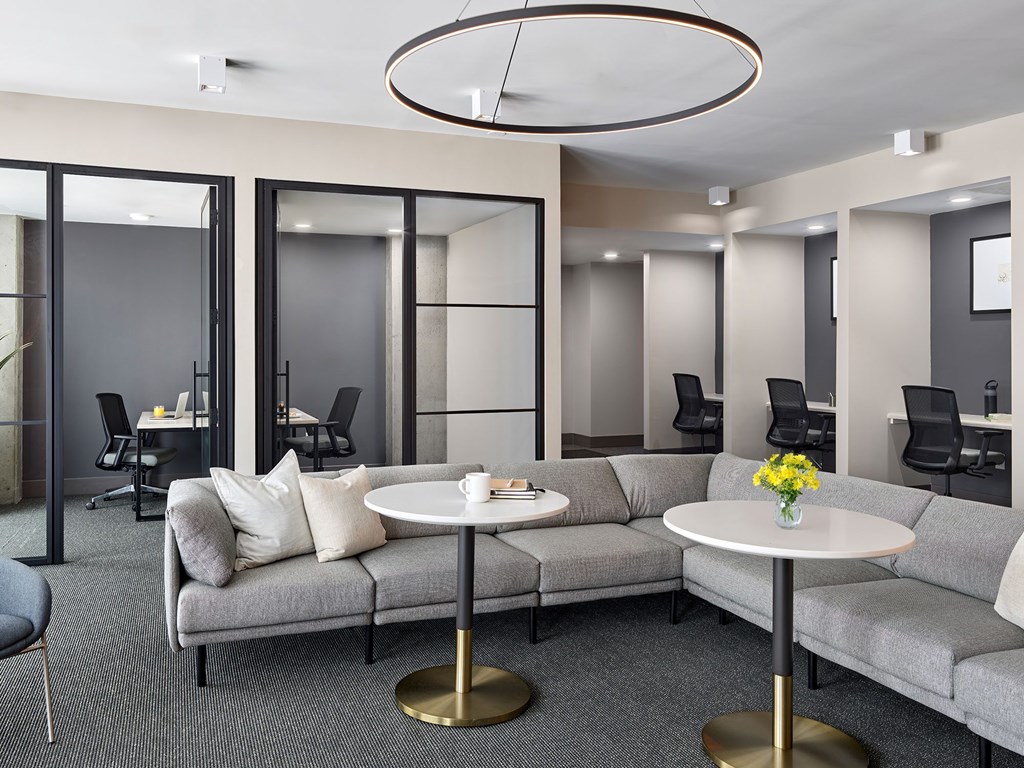 A modern living room with grey couches and a white coffee table.