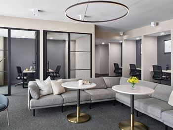 A modern living room with grey couches and a white coffee table.