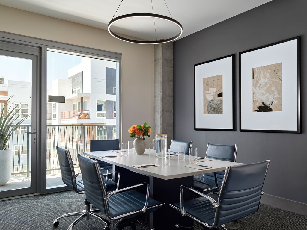 A conference room with a table, chairs, and pictures on the wall.
