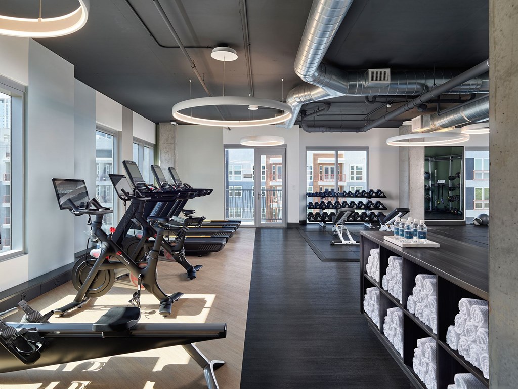 A gym with treadmills, exercise bikes, and weights.