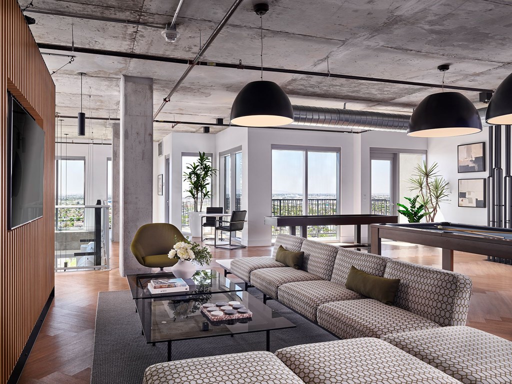 A modern living room with a glass coffee table and patterned sofas.