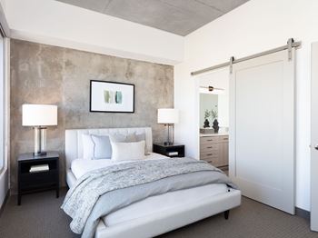 A bedroom with a large bed and a painting above it.