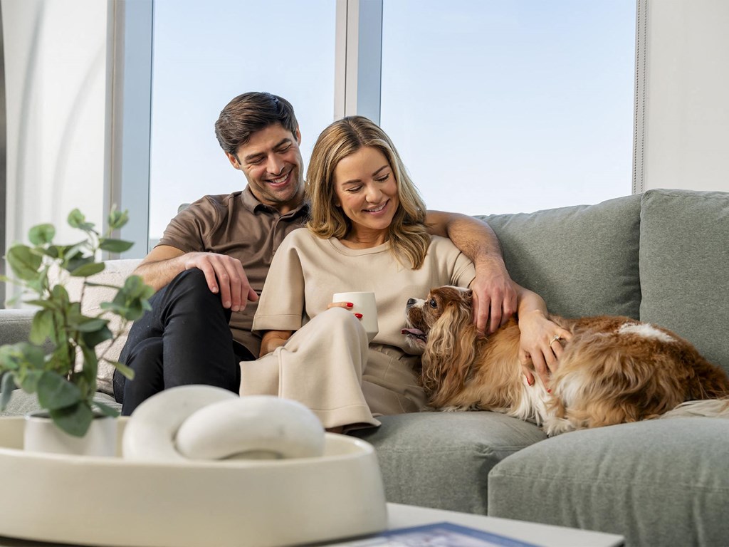 a man and woman sitting on a couch with a dog at AVE Phoenix Sky, Phoenix, AZ