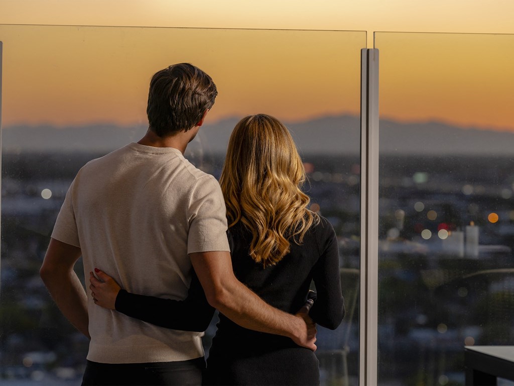 a man and woman looking out of a window overlooking the city at sunsetat AVE Phoenix Sky, Phoenix, 85003