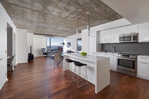 A kitchen with a white counter and a stove top oven.