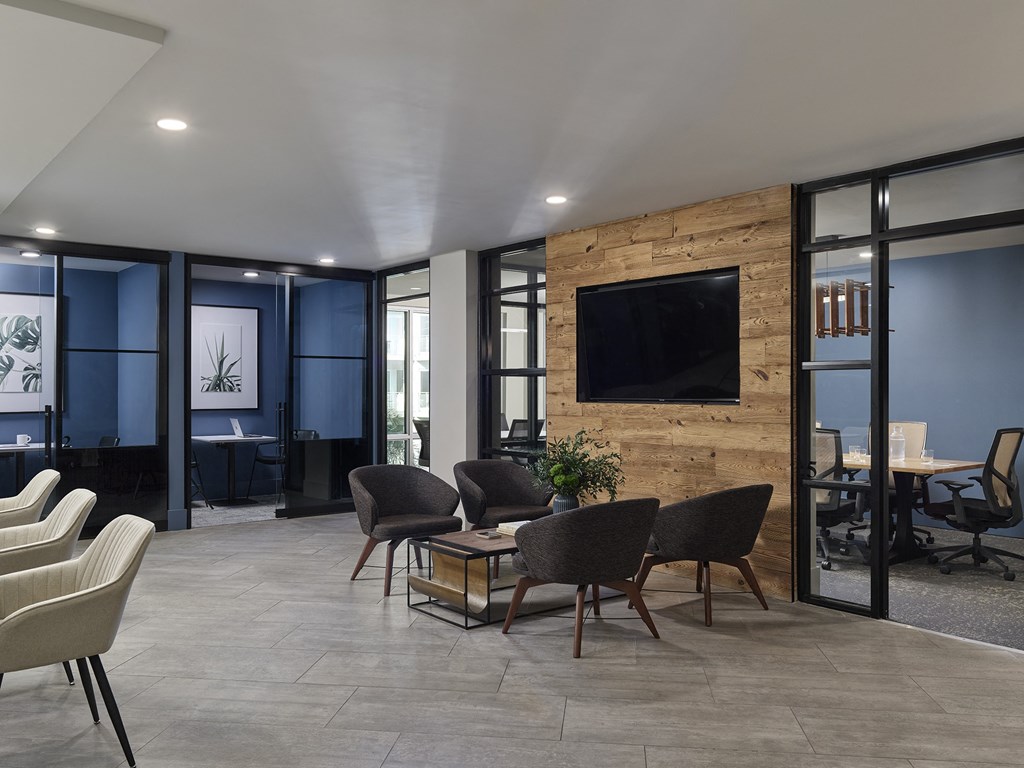 A modern living room with a stone wall and a flat screen TV.