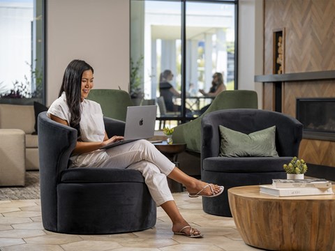 a woman sitting in a chair with a laptop