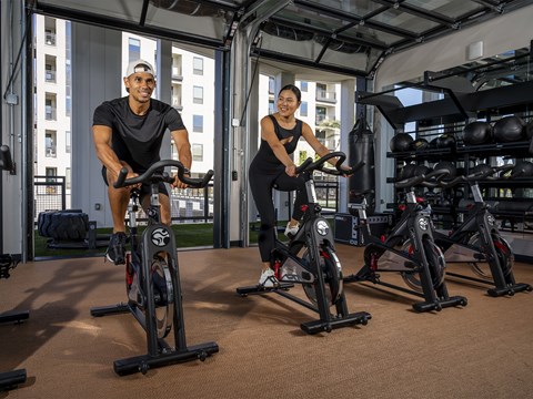 two men working out on exercise bikes in a gym