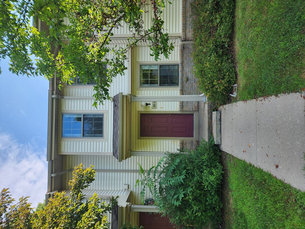 A house with a red door and a window with a curtain.