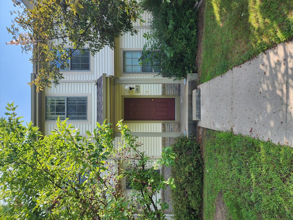 A white building with a red door and windows.