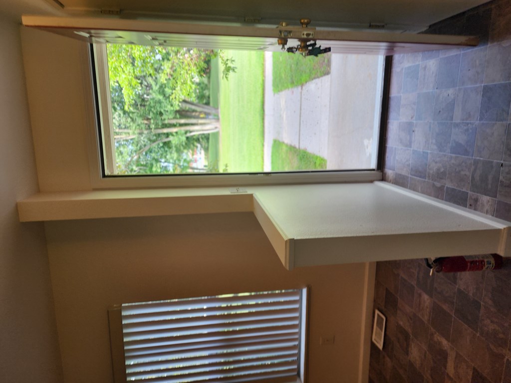 A window with blinds and a window sill.