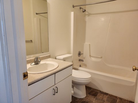 A white bathroom with a sink, toilet, and bathtub.