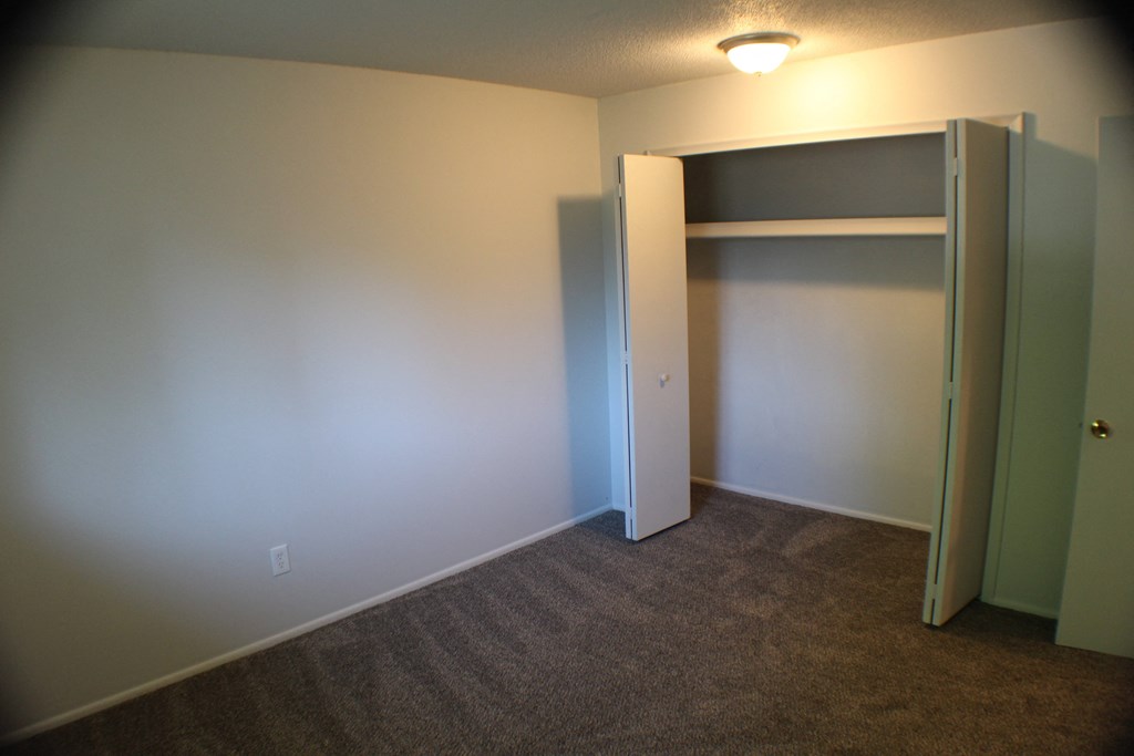 a bedroom with a closet and a door open