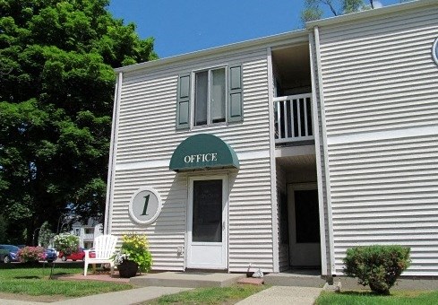 a white building with a green sign on the side of it