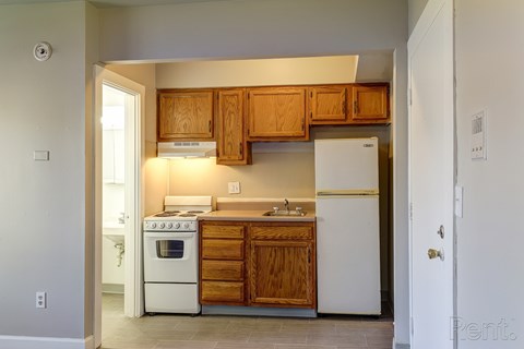 A kitchen with wooden cabinets and white appliances.