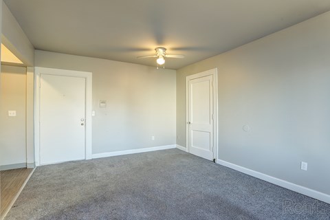 A spacious room with a carpeted floor and two doors.