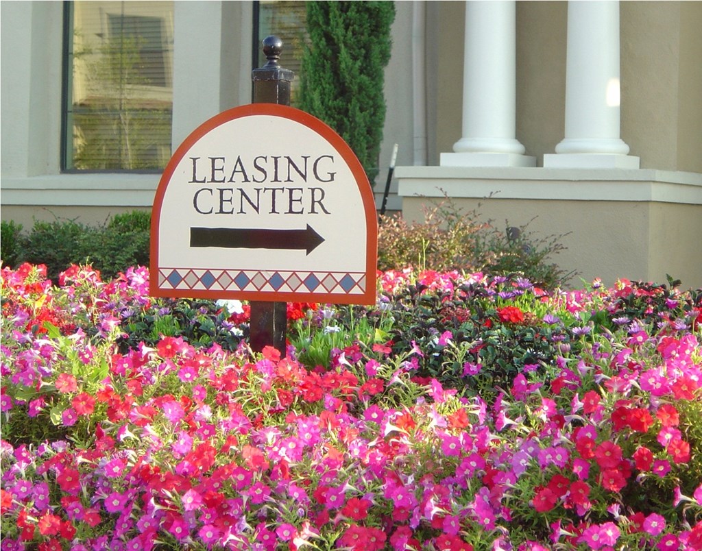 a sign that reads leasing center in front of flowers