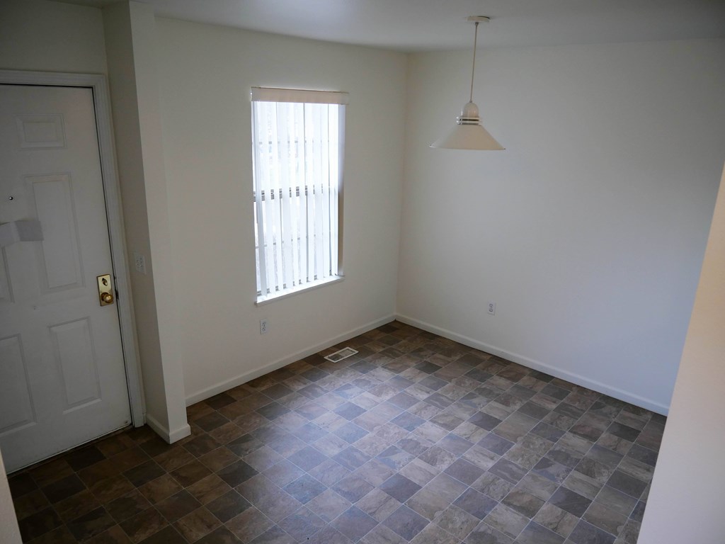 A room with a checkered floor and a window with blinds.