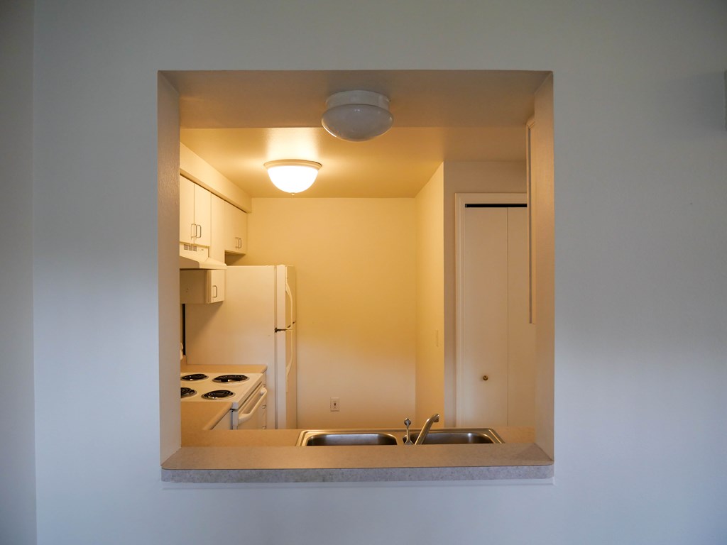 A small kitchen with a refrigerator, stove, and sink.