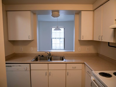 A kitchen with white cabinets and appliances.
