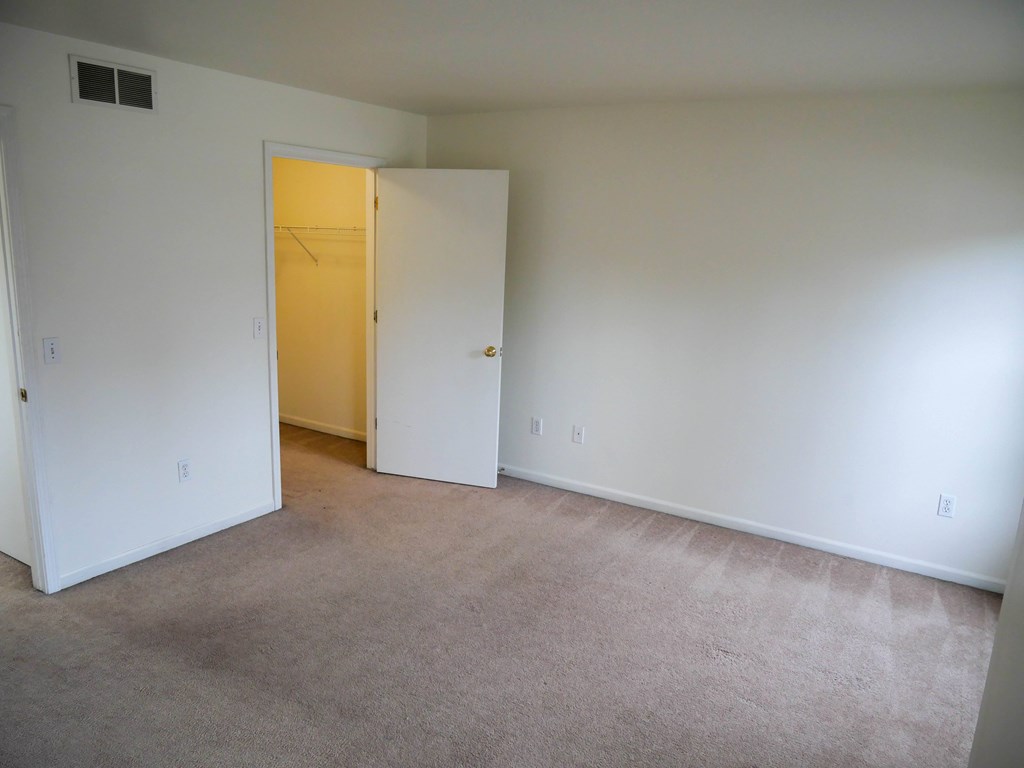 A room with a carpeted floor and a closed door.