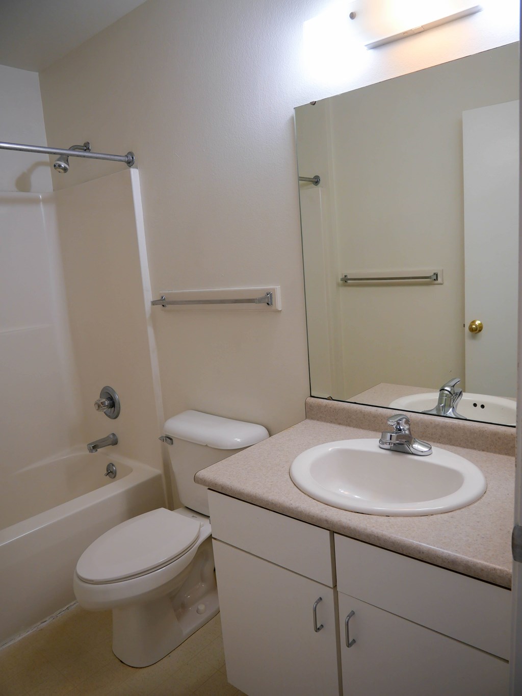 A white toilet sits next to a white sink in a small bathroom.