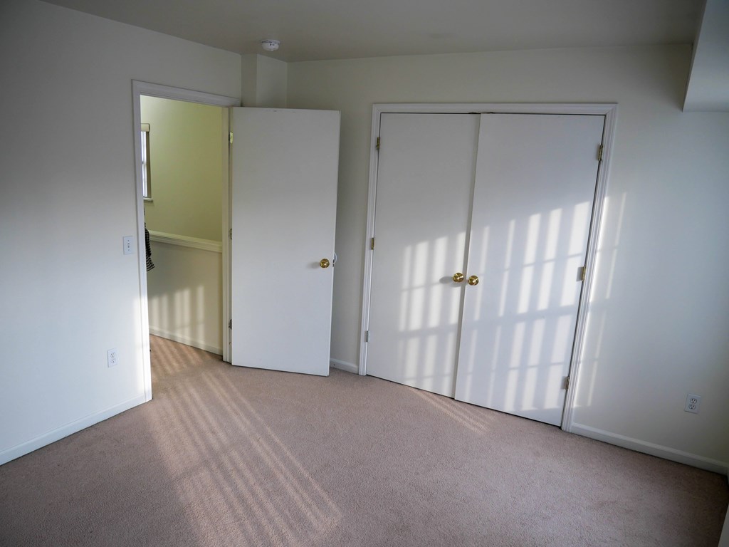 A room with two white doors and a carpeted floor.