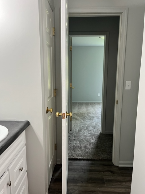 the view from the bathroom into the hallway with the door open