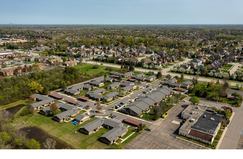 A bird's eye view of a residential area with houses and a parking lot.